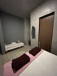 a bedroom with a bed with two brown pillows on it at Suíte Sete Colinas in Garanhuns