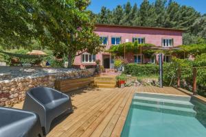 a house with a wooden deck and a swimming pool at Villa vue mer panoramique & piscine chauffée in Toulon