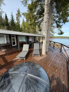 a deck with chairs and an umbrella on a house at Tilhi 1 Cottage in Piojärvi +64 photos