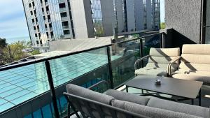a balcony with chairs and a table and a pool at Beach Apartment Chakvi in Chakvi