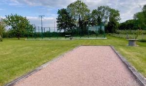 a park with a basketball hoop and a bench at Villa 1h30 de Paris - Padel - Piscine - 7 ch - 22 pers in Épinay