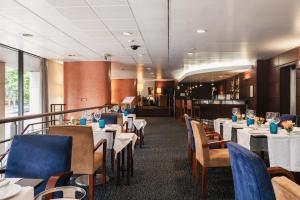 a restaurant with white tables and blue chairs at Hotel Marques De Pombal in Lisbon