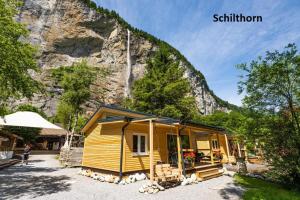 a tiny house in front of a mountain at Camping Jungfrau in Lauterbrunnen +53 photos