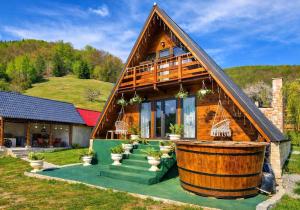 a large wooden house with a large barrel at A frame Ina și Cristi in Tîrsa