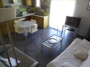 a living room with a table and a kitchen at Oustalou in Saint-Rome-de-Tarn