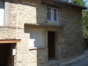 a stone building with a window and a door at Oustalou in Saint-Rome-de-Tarn