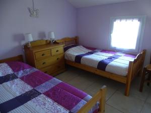 a bedroom with two beds and a window at Oustalou in Saint-Rome-de-Tarn +1 photo