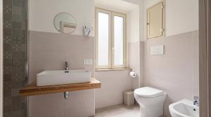 a white bathroom with a sink and a toilet at Il Marchesino B&B in Pizzo
