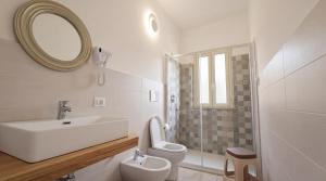 a bathroom with a sink and a toilet and a mirror at Il Marchesino B&B in Pizzo