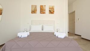 a bedroom with a large bed with two paintings on the wall at Il Marchesino B&B in Pizzo