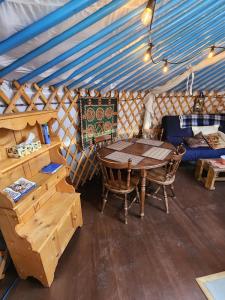 a room with a table and chairs in a yurt at COTC - The Coulee Yurt - Suite in Castor