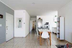 a kitchen with white walls and a table and chairs at Casa en San Rafael - 6 personas con parrilla y cochera in San Rafael
