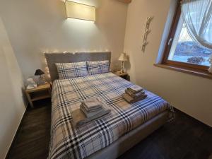 a bedroom with a bed with two towels on it at Alpine Heaven in Borca di Cadore