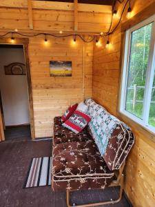 a couch in a log cabin with pillows on it at COTC - The Grouse House - Suite in Castor