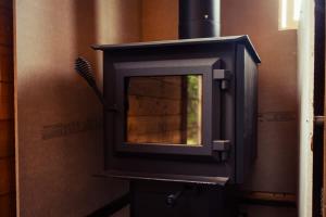a wood stove with a brush inside of it at COTC - The Grouse House - Suite in Castor +56 photos