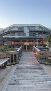 a building with a wooden boardwalk in front of it at Mystic Sands in Emerald Isle