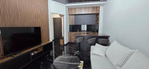 a living room with a couch and a flat screen tv at Beach Apartment Chakvi in Chakvi +3 photos