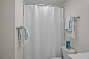 a bathroom with a shower curtain and a toilet at Mystic Sands in Emerald Isle +30 photos