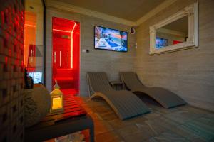 two benches in a room with a tv on the wall at Hotel Sara & SPA in Prishtinë
