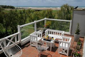 a balcony with two chairs and a table and a bird at Refugio de Mar in Miramar