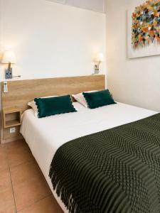 a bedroom with a large bed with green pillows at Hotel Alata in Alata