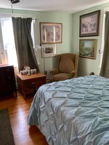a bedroom with a bed and a chair at Half a Mansion in Pomfret