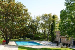 a swimming pool in a yard with chairs and trees at Mas Joanmiquel - Masía histórica exclusiva in Les Olives