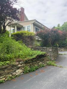 a house with a stone wall in front of a street at Half a Mansion in Pomfret