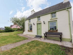 a white house with a green door and a bench at Beacon House in Haverfordwest
