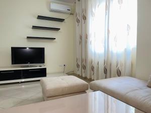 a living room with a couch and a tv at Rana e Hedhun Beach House in Shëngjin