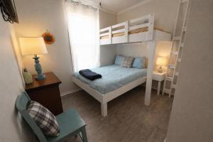 a small bedroom with a bunk bed and a desk at Beautiful Pensacola beach house in Pensacola Beach