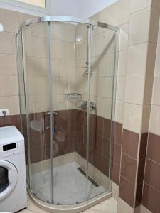 a shower with a glass door next to a washing machine at Rana e Hedhun Beach House in Shëngjin +11 photos