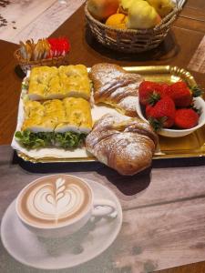 a tray of pastries and a cup of coffee and fruit at B&B Tre di Cuori in Campiano +10 photos