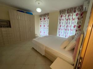 a bedroom with a large white bed with curtains at Rana e Hedhun Beach House in Shëngjin