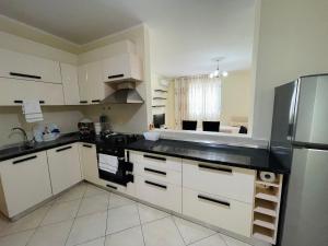 a kitchen with white cabinets and a stainless steel refrigerator at Rana e Hedhun Beach House in Shëngjin
