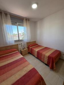 a bedroom with two beds and a window at Alpen1 Pompeya in Peniscola