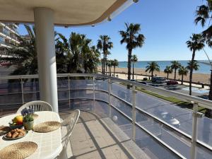 a balcony with a table and chairs and the beach at Alpen1 Pompeya in Peniscola