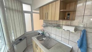 a small kitchen with a sink and a window at Apartament Ultra-Central Rm Valcea in Râmnicu Vâlcea +24 photos
