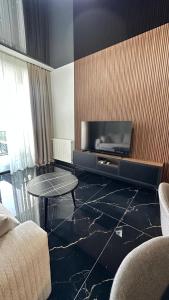 a living room with a tv and a table at Beach Apartment Chakvi in Chakvi