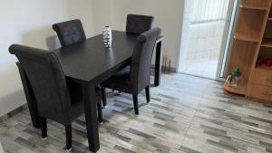 a black dining room table with black chairs at Apartament Ultra-Central Rm Valcea in Râmnicu Vâlcea