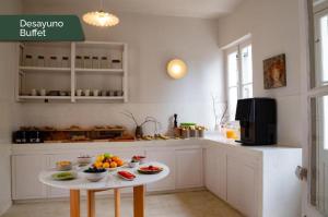 a kitchen with a table with bowls of fruit on it at Casa Lahusen in Colonia del Sacramento