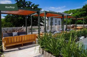 a pavilion with a bench and tables in a garden at Casa Lahusen in Colonia del Sacramento