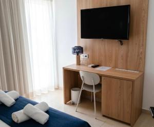 a room with a desk with a television on a wall at Hotel Iberflat Marynton in Benicarló
