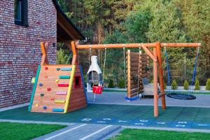 a playground with a slide and a climbing frame at DOMKI KASZUBY Cegła & Relaks in Stężyca