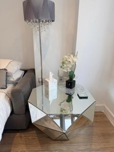 a glass table with a lamp and a couch at Blanco Brillo in Colchester +8 photos