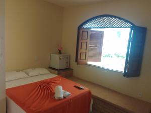 a bedroom with a bed with an open window at POUSADA CANEDO in Guaibim +64 photos