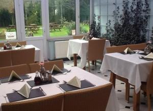 a restaurant with tables and chairs with white table cloth at The Cottage Inn in Craster