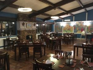 a dining room with tables and chairs and a fireplace at The Cottage Inn in Craster
