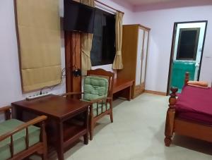 ein Zimmer mit Schreibtisch, Tisch und Stühlen in der Unterkunft Hostel samui Sunset in Ban Na We