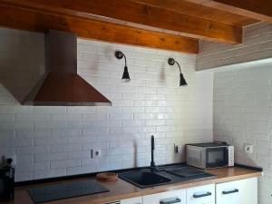 a kitchen with a sink and a stove top oven at Casa do Tejo de Alcochete in Alcochete